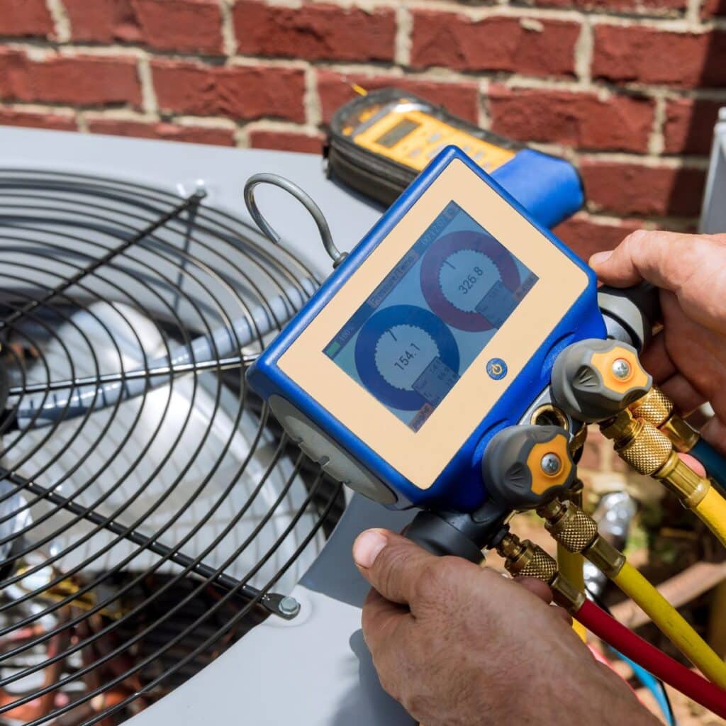 air conditioning tech using a tool on an air conditioning unit