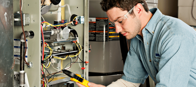 heater technician performing repairs on a residential furnace